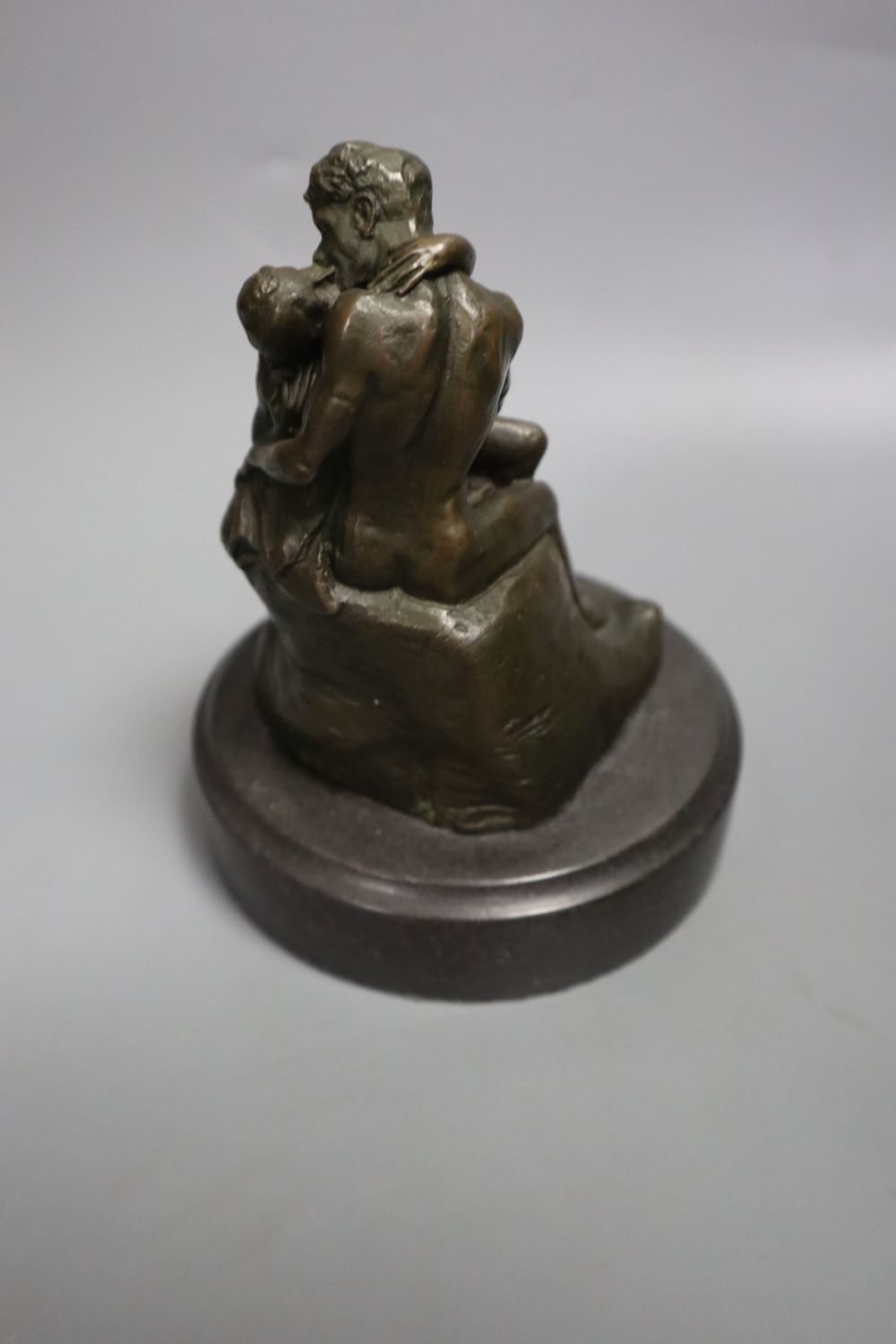 A cast metal sculpture Kiss after Rodin, height 14cm and another of Arabs